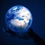Earth held up by a human hand in space